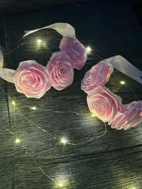 A pair of blush pink satin rose gajray with ribbon ties