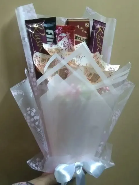 Chocolate gift bouquet in a white frosted wrap with a blue ribbon