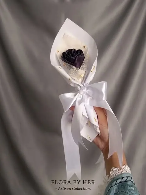 Single dark satin rose in white wrap with a white satin bow