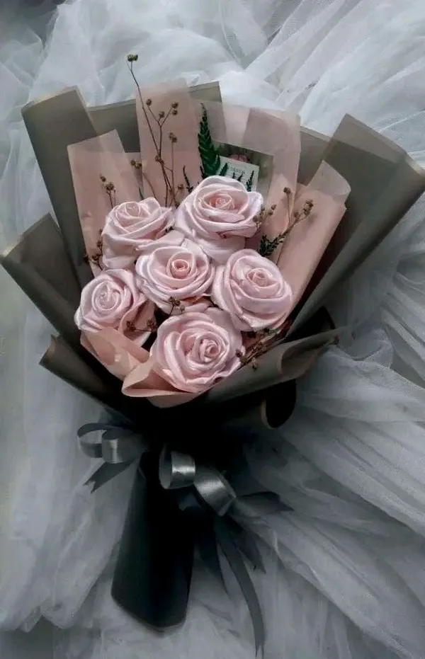 Pink satin roses with dried stems in grey wrap