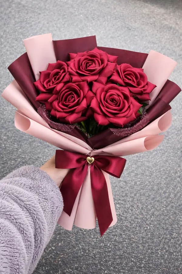Red satin roses in layered pink and wine wrap with a wine bow