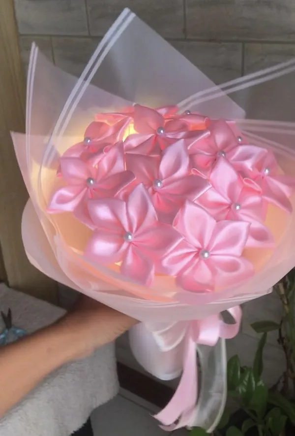 Pink satin lily bouquet with pearl centres glowing with fairy lights