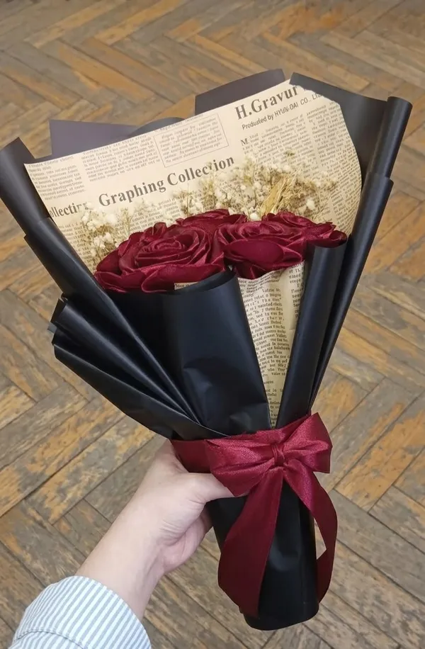 Wine satin roses with baby's breath in newsprint and black wrap